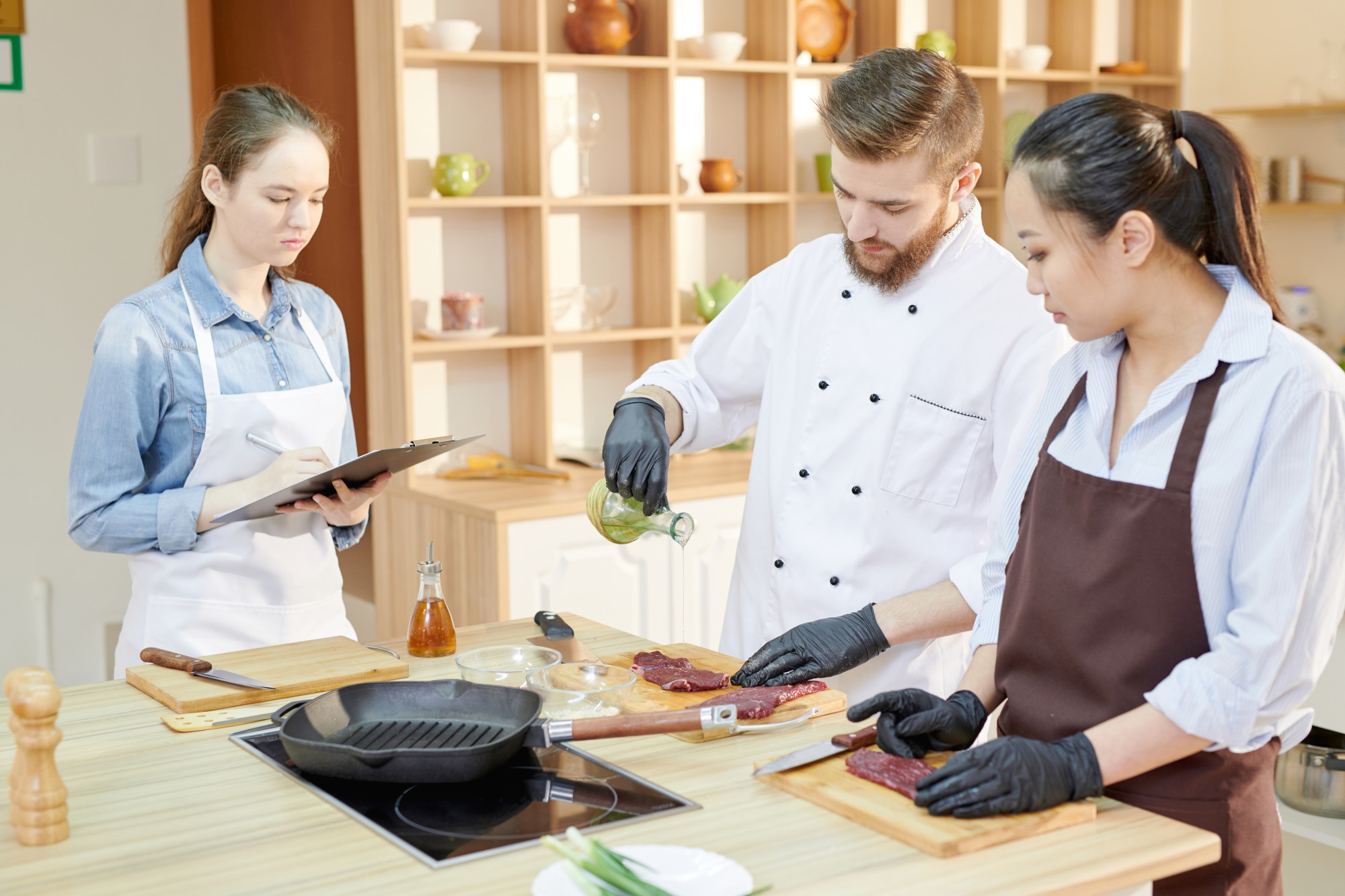Workshop chef instructing two students