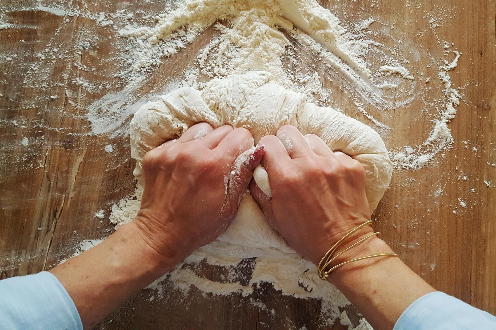 Close-up of hands kneading dough