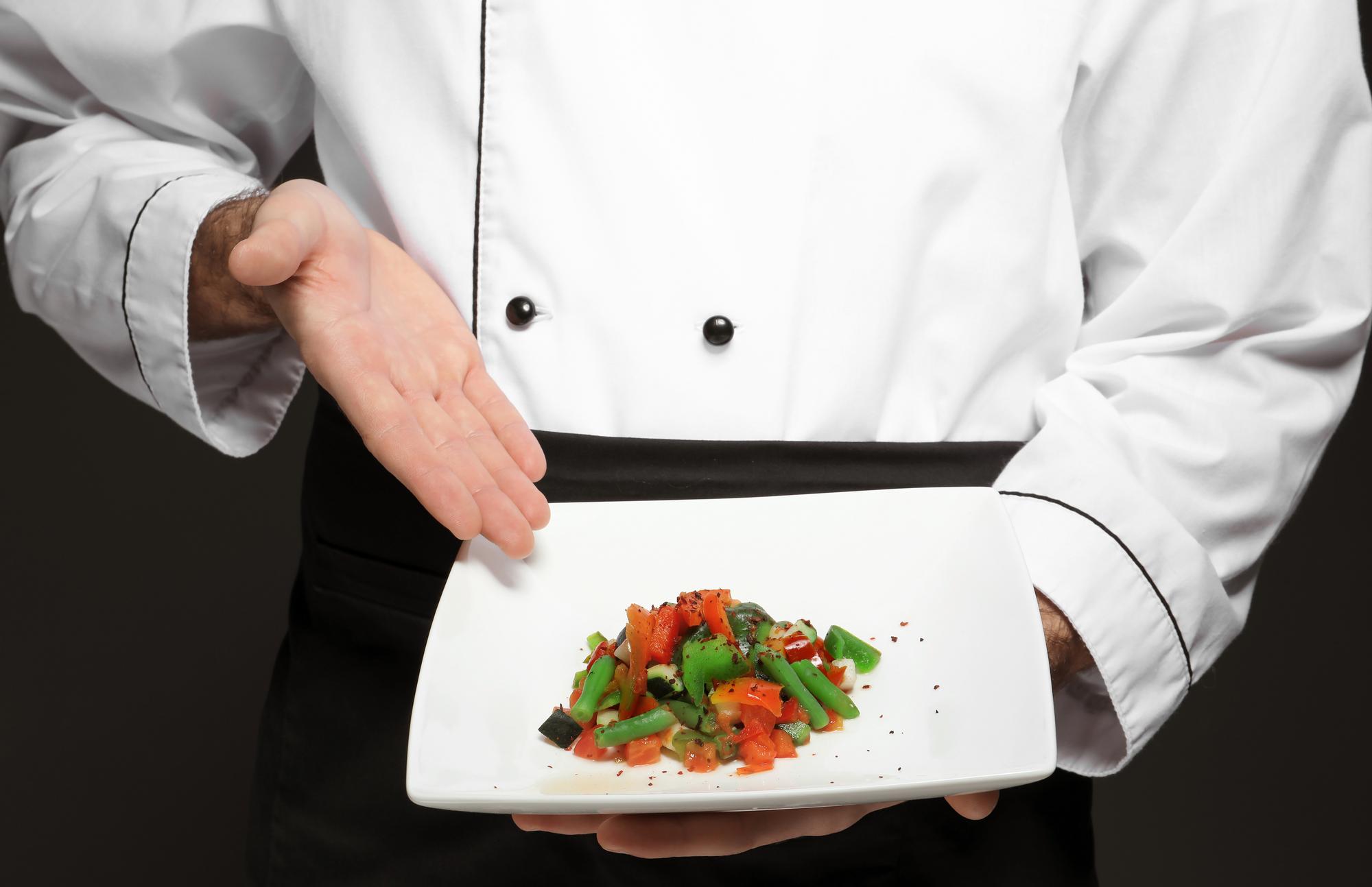 Chef preparing plated dish in elegant studio
